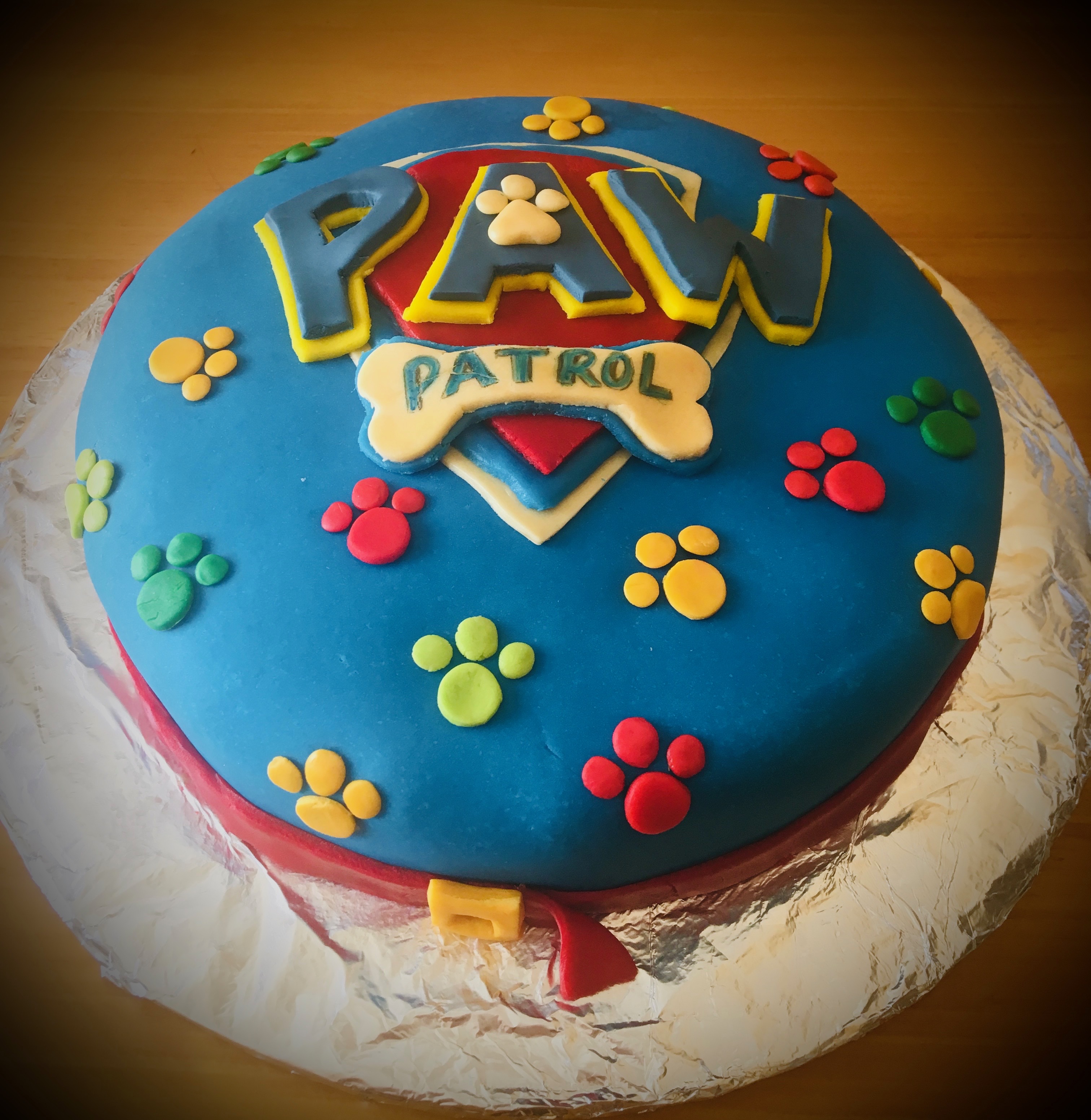 Paw Patrol themed cake with logo and paw prints